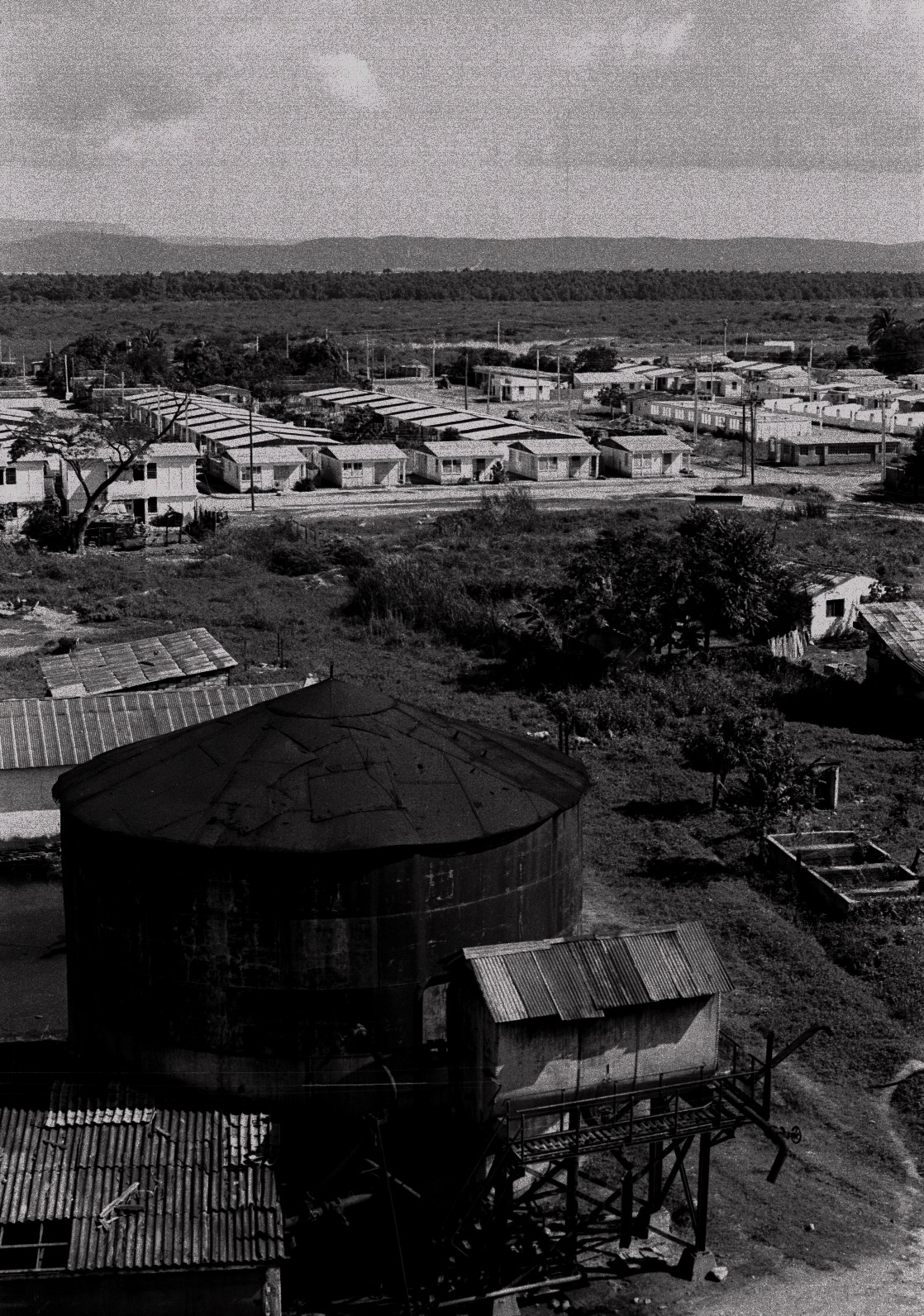 Vista aérea del Central Paraguay. Al fondo está la Base Naval de Guantánamo. El Central está en la segunda línea fronteriza con la Base. Las viviendas prefabricadas de los obreros sustituyeron los bohíos que a su vez habían desplazado a los barracones. (Foto: Alejandro Ramírez Anderson)