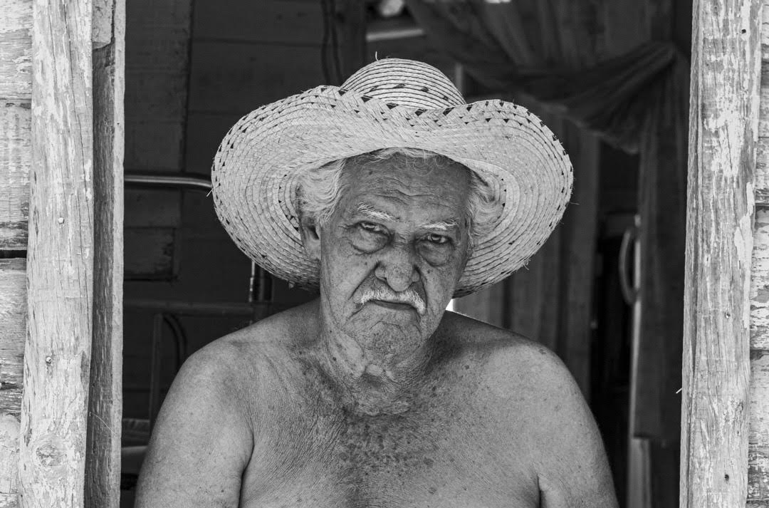 Alejandro Valdés Roy es un campesino de 83 años de edad. Vive en una casa alejada a varios kilómetros de la comunidad, con su esposa y uno de sus nietos. Dice Alejandro, que nunca desearía irse de su casa. Cuando pasó la última tormenta tropical por Pinar del Río, sus hijos, que hace tiempo emigraron hacia el pueblo (así nombran los habitantes del Hoyo a la ciudad de Pinar del Río), le pidieron que saliera del Hoyo, pero él se negó (Foto: Lázaro Lemus).