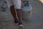 Hombre en Cuba transportando un cilindro de gas licuado para uso doméstico.