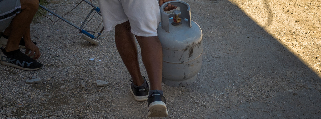 Hombre en Cuba transportando un cilindro de gas licuado para uso doméstico.