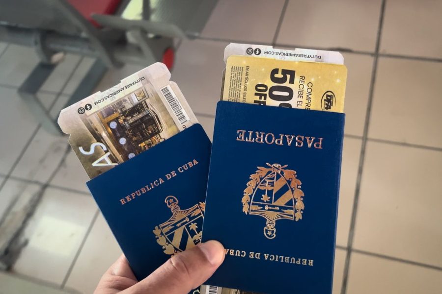 Mano sosteniendo dos pasaportes cubanos y boletos de viaje, simbolizando los procesos de migración desde Cuba hacia Canadá.